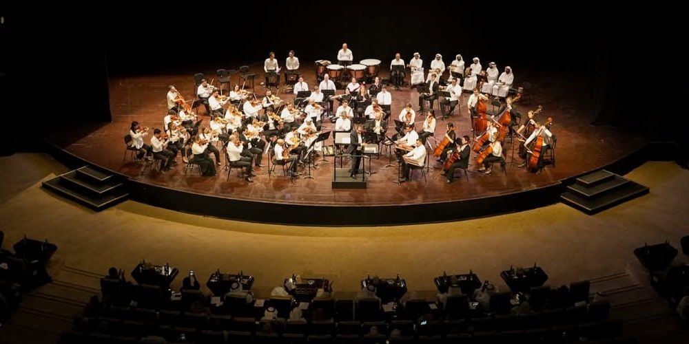 UAE National Orchestra performing classical music in the wood-paneled Dubai Opera auditorium